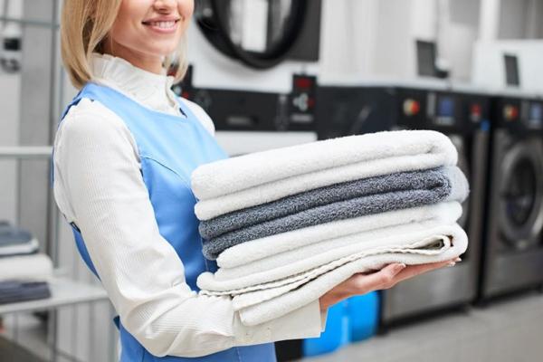 woman holding folded towels